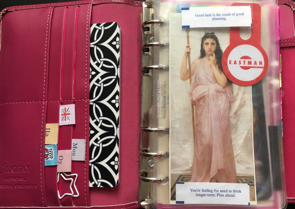 Inside a Filofax with sticky notes and postcards and fortunes